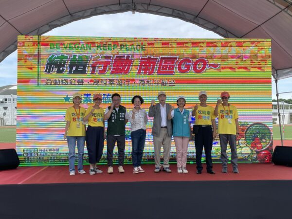 主辦單位、貴賓與參與民眾一同登台合影,手持標語高喊口號,為「純素減碳、友善動物、推動永續農業」畫下圓滿句點,象徵共同守護地球、推動純素立法的決心。圖/主辦單位提供